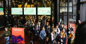 Teilnehmende der New Zealand Game Developers Conference mit NZGDA-Beschilderung