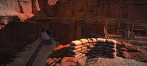 Spielszene aus Arizona Sunshine VR Legacy: Sandsackbarriere und Metallgerüste in einer rotfelsigen Schlucht.